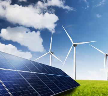 Waldbröl - Ökostrom Solarmodule auf einer Wiese mit mehreren Windrädern vor blauem Himmel.
